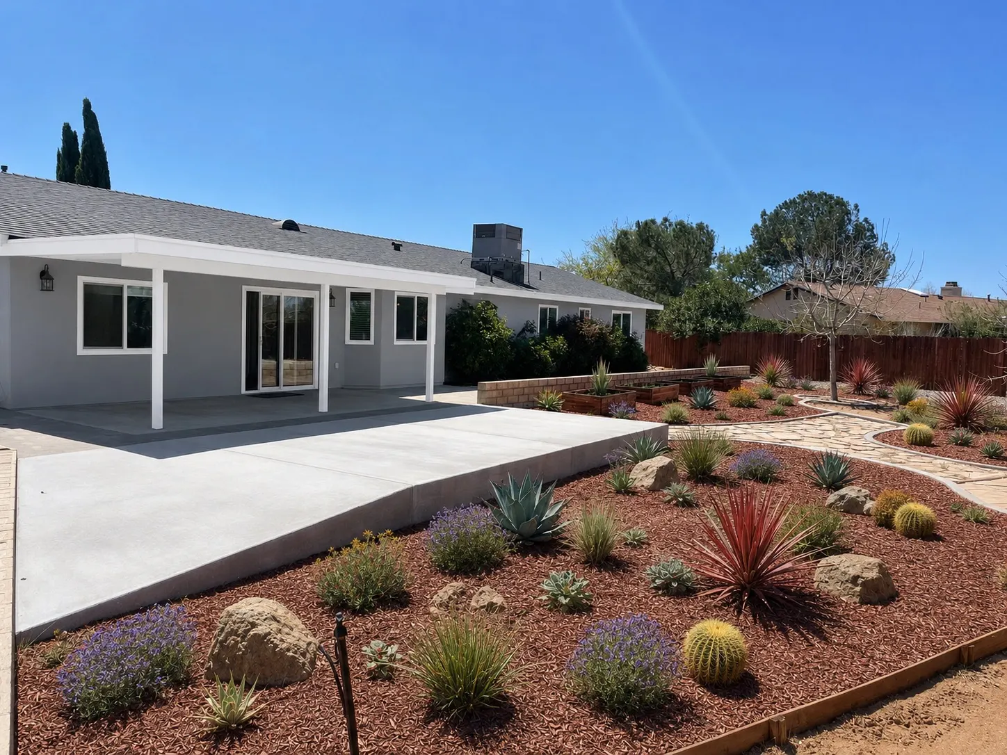 The Apple Valley facility at 10916 Saratoga Road: a single-storey house with a covered patio, open concrete terrace and drought-tolerant desert planting.