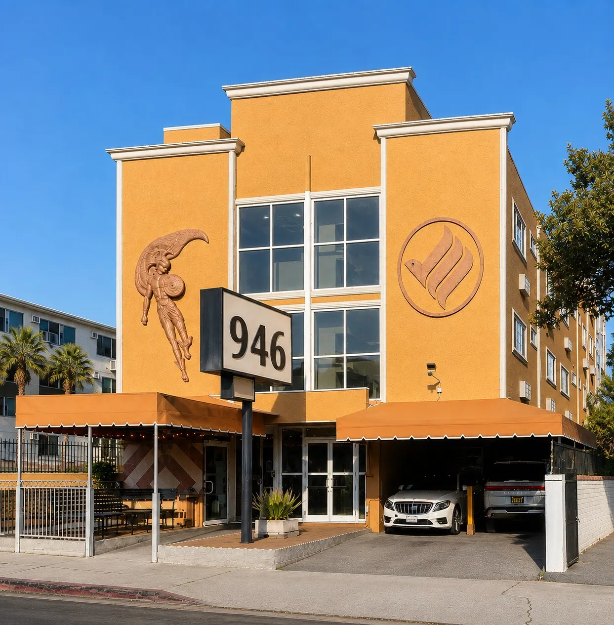 The Los Angeles facility at 946 South Bonnie Brae Street: a four-storey building with warm ochre stucco, orange awnings over the entrance and carport, and a sign reading 946.